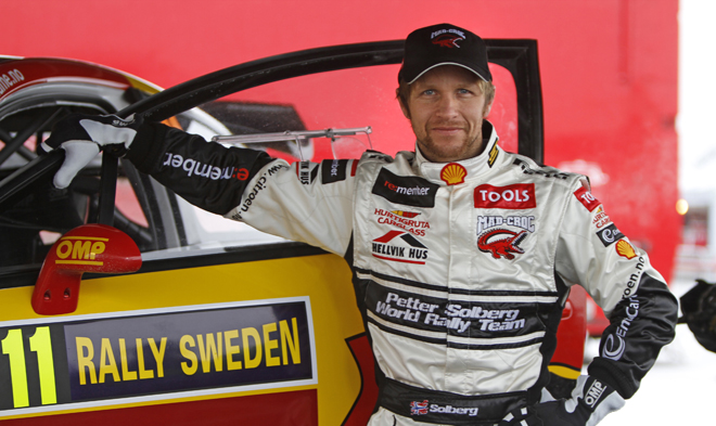 Petter Solberg stands next to his Citroen rally car